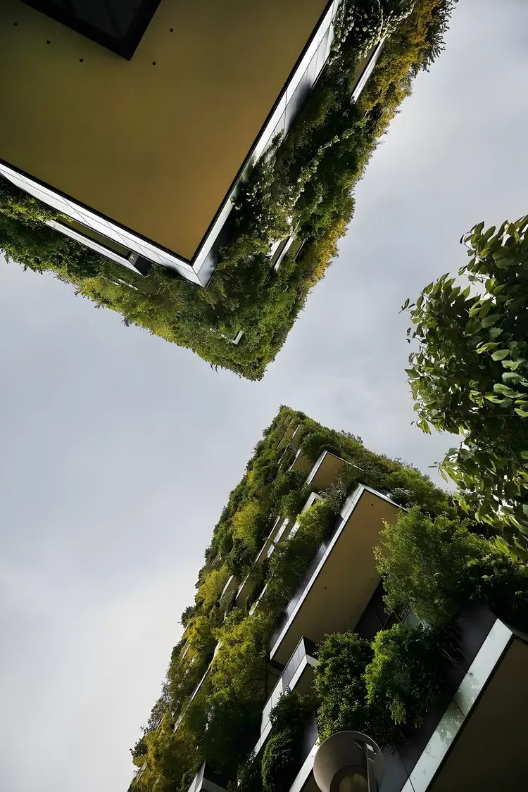 Torres do Bosco Verticale vistas de baixo, com varandas cobertas de vegetação contra um céu nublado